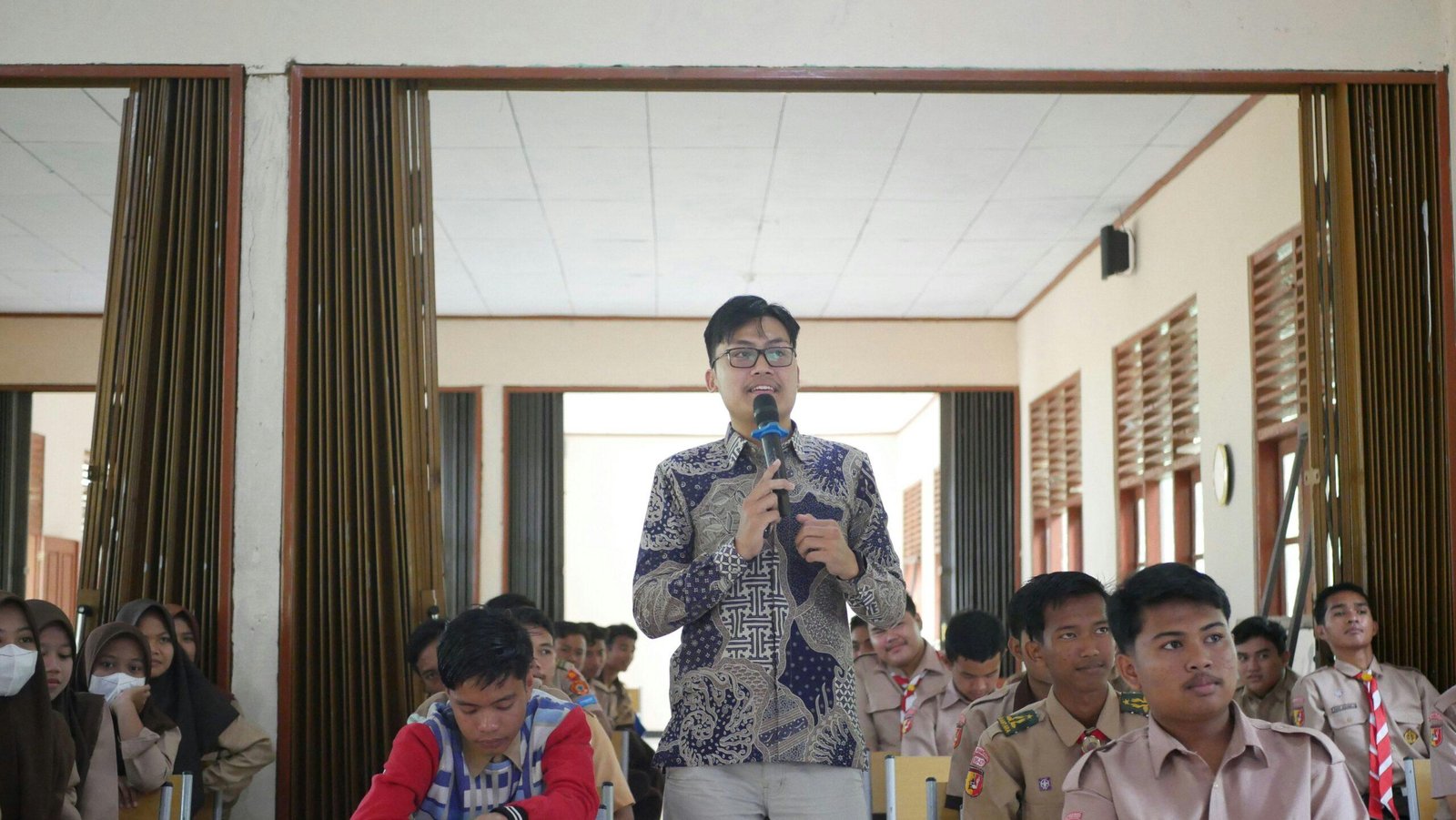 Woman smiling in front of podium holding 'thank you' sign